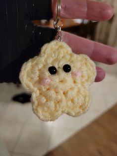 a crocheted keychain with a small face on it's side