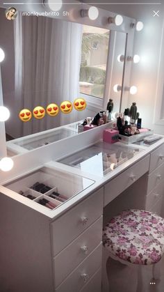 a white vanity with drawers and lights on the mirror above it is an emoticive smiley face