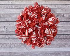 a red and white mesh wreath on a wooden wall