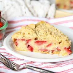 a slice of strawberry crumb pie on a plate next to a bowl of strawberries