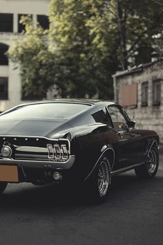 an old mustang muscle car parked on the street