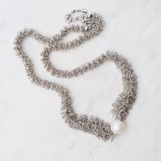 This unique & delicate jewelry is made from pieces of very fine ball chain that are laser soldered by hand to create detailed, beautiful patterns. It is soft and fluid, with a "silk"-like feeling. Adds a textured, wearable, and unique touch to any look! Woven ball chain Rhodium plated sterling silver 17" with 1.5" extender Lobster clasp Handmade in Thailand, handpicked in person by our buyers Delicate Jewelry, Ball Chain, White Pearl, Beautiful Patterns, Pearl White, Rhodium Plated, Silk, Chain, Sterling Silver