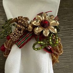 a white napkin with gold, red and green flowers on it's center piece