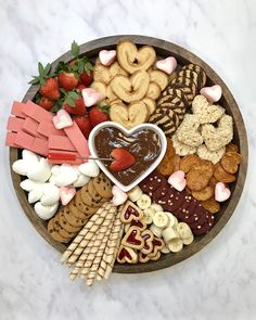 a heart shaped bowl filled with assorted snacks