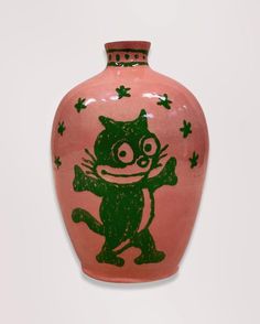 a pink and green vase with an image of a cat painted on it's side