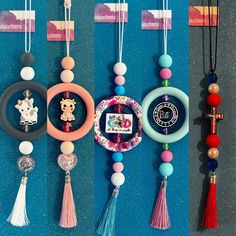 several necklaces hanging on the wall with different colors and designs attached to each bead