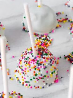 cake pops covered in sprinkles and white frosting with colorful candies