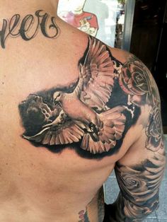 a man with tattoos on his back and chest has two birds in the middle of it