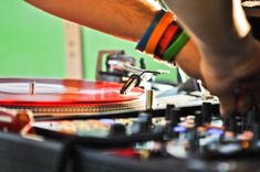 a dj mixing music with his hands on the record player's turntables