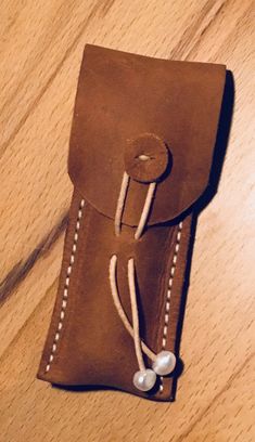 a brown leather case sitting on top of a wooden table