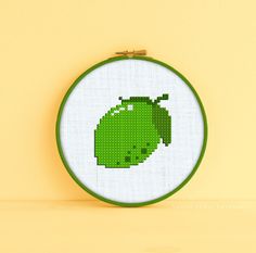 a cross - stitch pattern of a green car on a white background with a yellow wall behind it