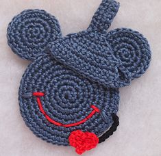 a crocheted mouse hat with a red heart on it