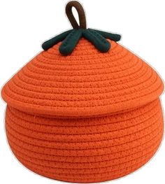 an orange knitted pot holder with a brown handle on the top and black handles