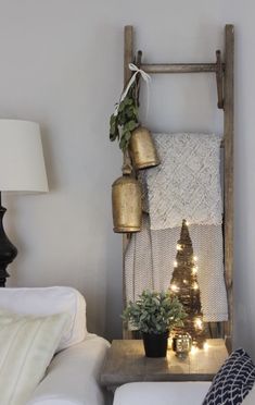 a living room with a christmas tree and potted plants on the shelf next to it