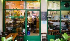 an outside view of a restaurant with many tables and chairs in front of the window