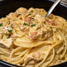 pasta with chicken and sauce in a black bowl