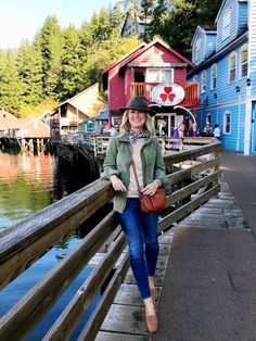 a woman standing on a dock next to some houses