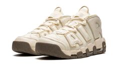 The Nike Air More Uptempo "Coconut Milk" is a versatile and neutral-based colorway of Scottie Pippen’s iconic signature shoe.  The “Coconut Milk” Air More Uptempo is yet another popular release for the old school hoops shoe that was worn by “Pip” with the Chicago Bulls in 1996.  The shoe features a Coconut Milk canvas construction with tonal, oversized “AIR” branding on the sides in leather.  A tonal Swoosh is embroidered on the toe while a jeweled version of the iconic Nike branding is found on Nike Air More Uptempo 96, Nike Air Uptempo, Gold Trainers, Nike Factory, Nike Air More Uptempo, Nike Air More, Nike Branding, Scottie Pippen, Veja Sneakers