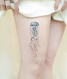 a woman's legs with a jellyfish tattoo on her left thigh and leg