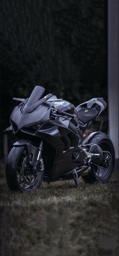 a black motorcycle parked on top of a lush green field