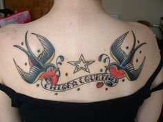 the back of a woman's shoulder with two birds and an inscription on it