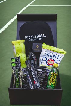 a box filled with sports items on top of a tennis court