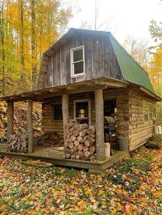 a log cabin in the woods with lots of wood stacked up on top of it