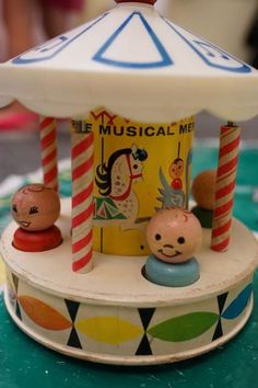 a toy carousel with people on it and a white umbrella over the top that says musical me