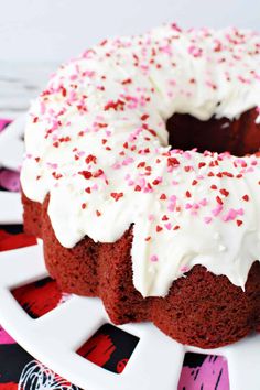 a bundt cake with white frosting and sprinkles on a plate