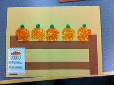 an art project with oranges on top of a piece of paper that is cut out to look like pumpkins