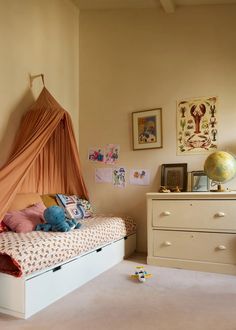 a child's bedroom with an orange canopy over the bed