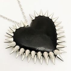 The Double Row Spiked Heart is a Bunny Paige classic. Dozens of spikes are individually hand-applied to give each heart its iconic double row halo. Spiked Heart Pendant: 2.5" wide 16" silver plated or gunmetal chain + 2" extender 100% handmade All jewelry comes beautifully gift wrapped Gothic Jewelry With Spikes For Alternative Fashion, Valentine's Day Punk Party Jewelry, Black Spiked Jewelry For Festival, Punk Heart Pendant Jewelry For Valentine's Day, Trendy Black Stud Jewelry, Punk Jewelry With Spikes, Edgy Spiked Jewelry For Parties, Trendy Black Studded Jewelry, Punk Jewelry With Spikes For Alternative Fashion