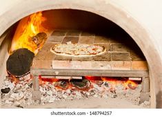 a pizza being cooked in an oven with fire coming from the top and on to the bottom