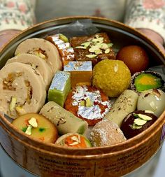 a basket filled with assorted pastries on top of a table next to a person