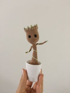 a small crocheted doll in a white cup