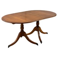 an oval dining table with three pedestals and two leaves