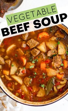 a bowl of vegetable beef soup on top of a white table with a green sign over it