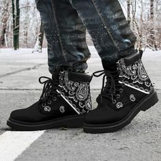 a pair of black boots with white tiger designs on the front and side, sitting on concrete