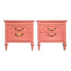 pair of pink nightstands with gold handles on each side and one drawer in the middle