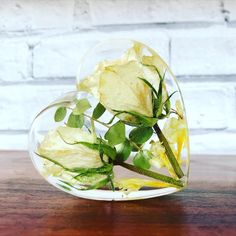 a vase filled with flowers on top of a wooden table