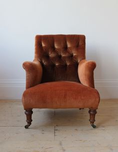 an old fashioned chair is upholstered against a white wall