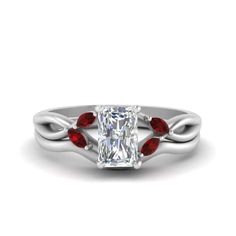 a white gold ring with red stones on the band and a center stone in the middle