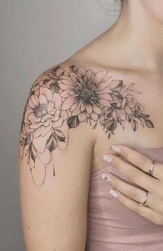 a woman with a flower tattoo on her arm and shoulder is looking at the camera