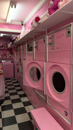 pink washers and dryers are lined up in a room