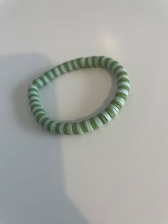 a green and white bracelet sitting on top of a table