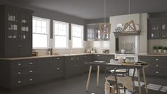 a large kitchen with gray cabinets and white walls, along with a dining table in the center