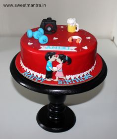 a red cake decorated with an image of two people kissing on the front and side