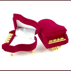 an open red velvet jewelry box with gold studs on the sides and inside, sitting on a white surface