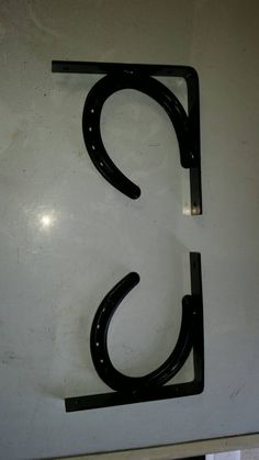 the letter c is made out of metal and has a black handle on it's side