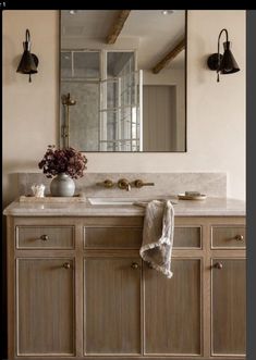 a bathroom with a large mirror above the sink and two lights on the wall next to it